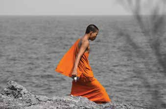 Figure in orange robes beside water